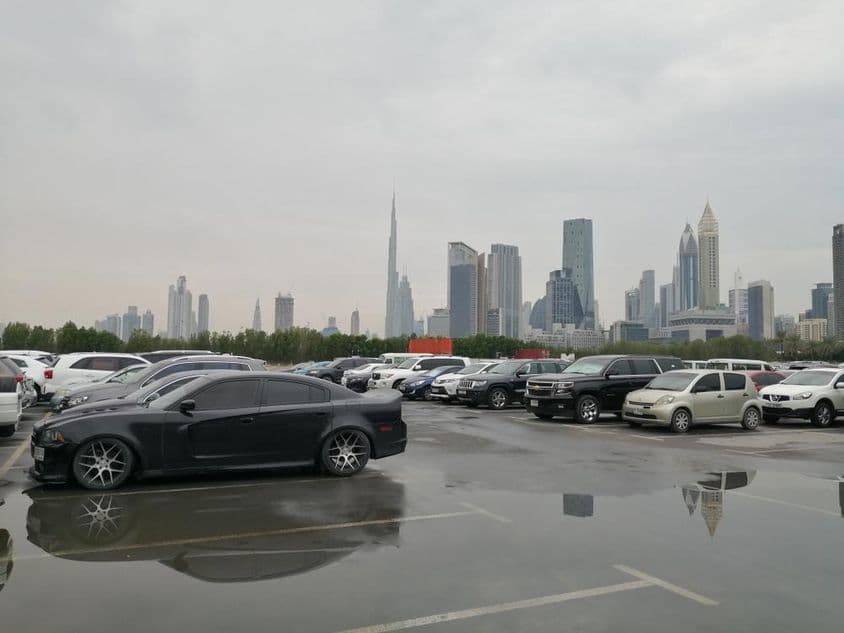 После сильного дождя дождевая вода скапливается на земле в парковочной зоне пустынной страны.