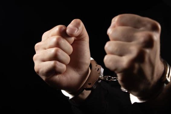 Закованные в наручники мужчины, арестованные за преступления.