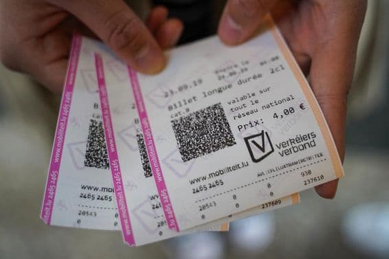 Молодой человек держит в руках билеты.