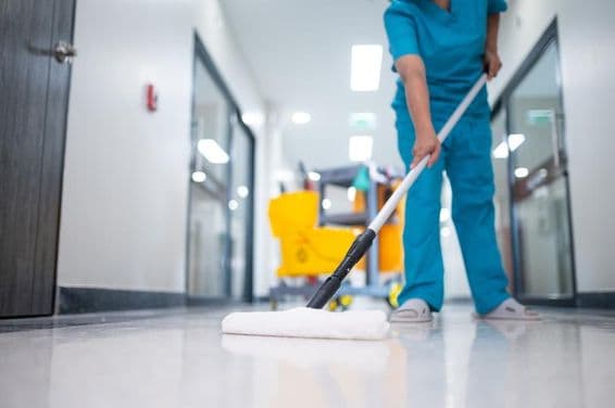 Уборщик моет пол в коридоре.