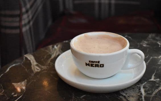 Чашка горячего шоколада на мраморном столе в Caffe Nero.
