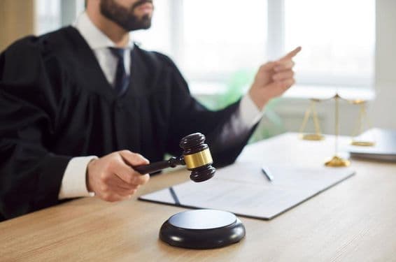 Судья стучит молотком, вынося приговор в зале суда.