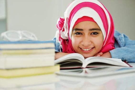 Красивая арабская мусульманка читает в колледже.