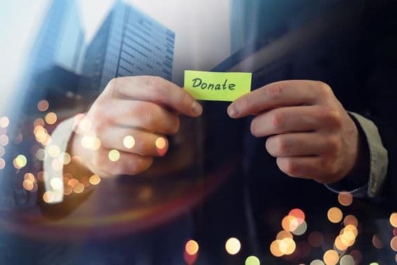 Предприниматель показывает документ со словом 'пожертвование'.