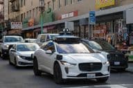 Роботакси Waymo, навигающее по оживленным, узким улицам Чайнатауна в Сан-Франциско.