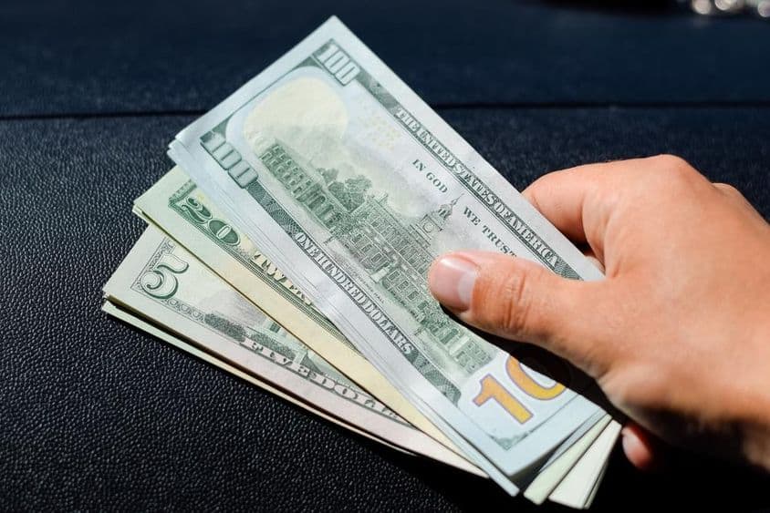 Пачка долларов в руке мужчины.