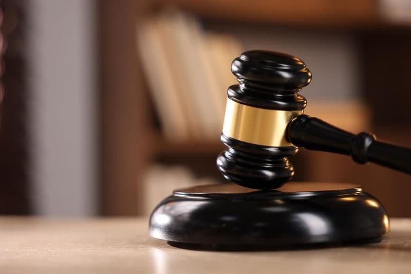 Судейский молоток на деревянном столе.