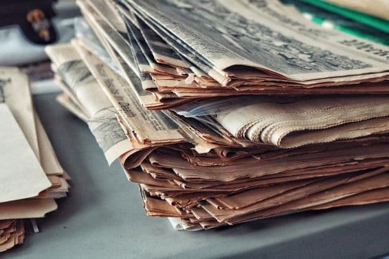 Старые газеты, сложенные со паутиной.