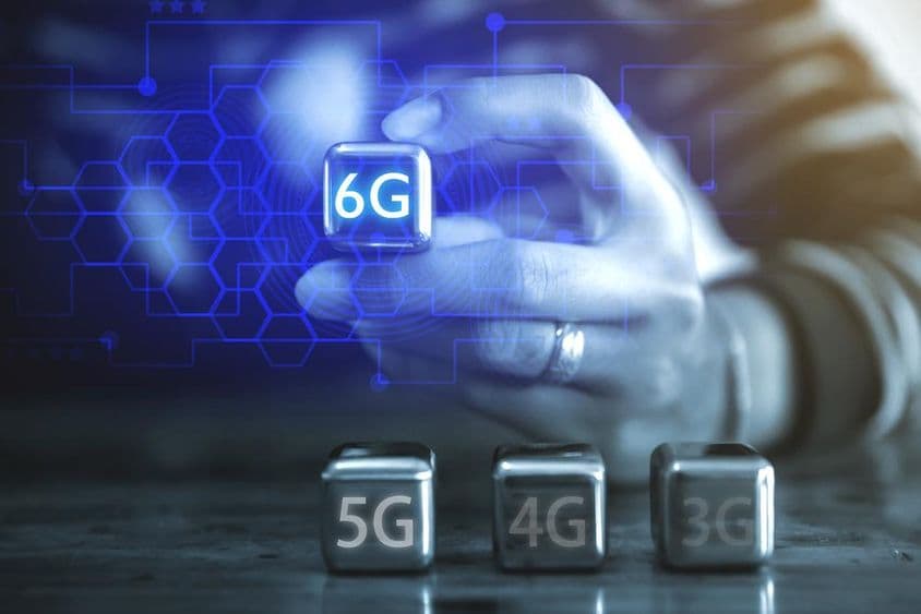 Молодой бизнесмен использует кубическую стальную сферу с надписью: 6G.