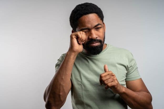 Человек, тревожно потирающий глаза, чувствующий раздражение и усталость.