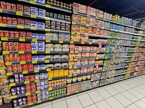 полка супермаркета с красочными консервированными продуктами, тунцом и овощами