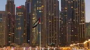 Вечерний вид на освещенный фонтан в Дубае