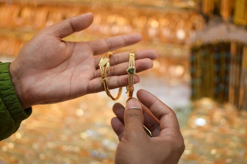 Рука примеряющая роскошный золотой браслет