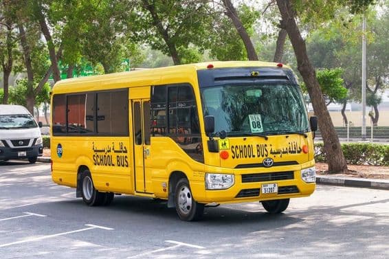 Toyota Coaster школьный автобус на улице в Дубае.