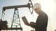 Нефтяной насос, инженер работающий с ноутбуком
