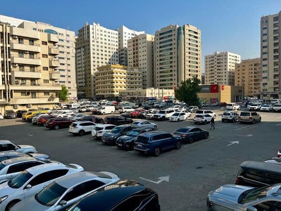 Большая парковка, окруженная автомобилями в Дубае