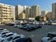 Большая парковка, окруженная автомобилями в Дубае