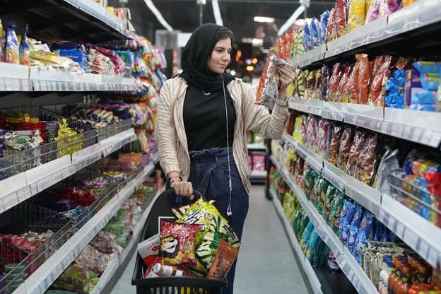Молодая арабская женщина в супермаркете